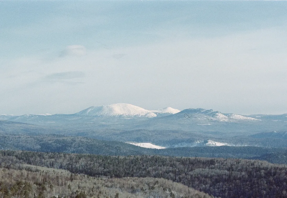 Scenic aerial view of snow-capped mountains and forests in Aigir, Bashkortostan, Russia.